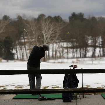 Image: Lone golfer works on his game under ominous skies at Northwest Golf Course in Silver Spring