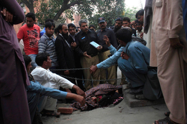 Image: Police collect evidence near body of Farzana Iqbal, killed by family members, at site near Lahore High Court building in Lahore
