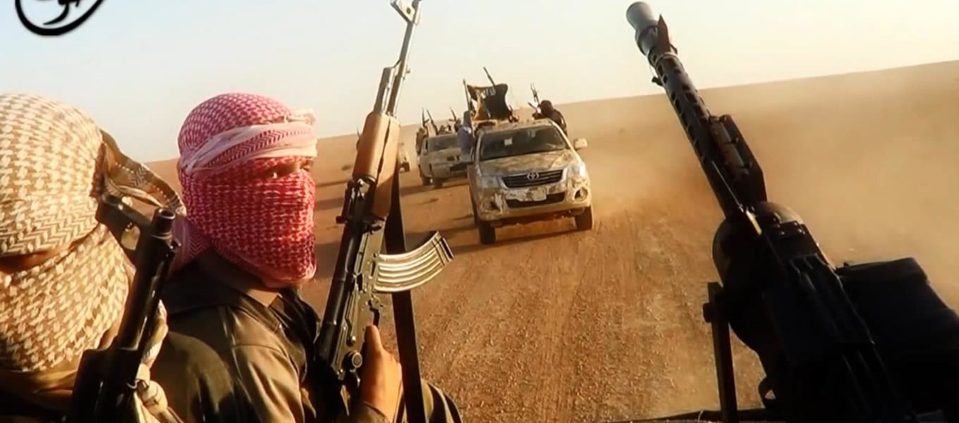 Image: ISIL militants driving in vehicles near the central Iraqi city of Tikrit