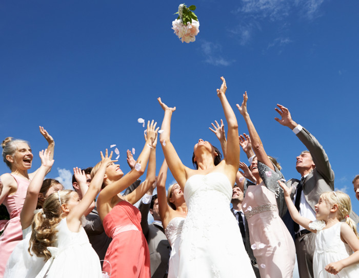 Bride Throwing Bouquet For Guests To Catch.