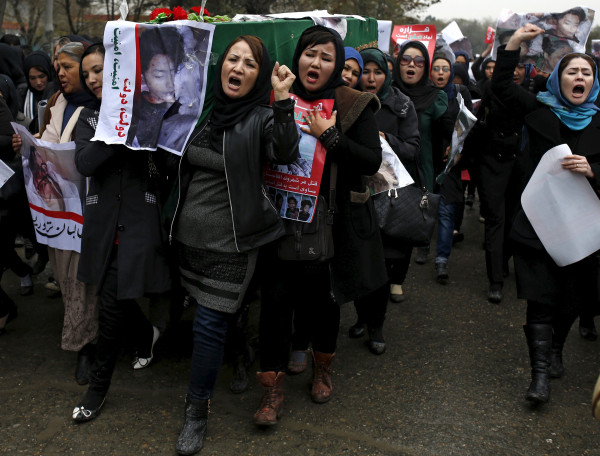 Image: Women chat slogans as they carry one of the coffins 
