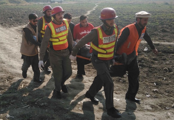 Image: Pakistani rescuers assist an injured victim outside the Bacha Khan University 