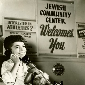 A Jewish Community Center promotional photo, circa 1950, shows a young boy carrying baseball equipment.