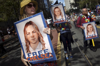 Image: People hold signs calling for the release of imprisoned wikileaks whistleblower Chelsea Manning while marching in a gay pride parade in San Francisco, California