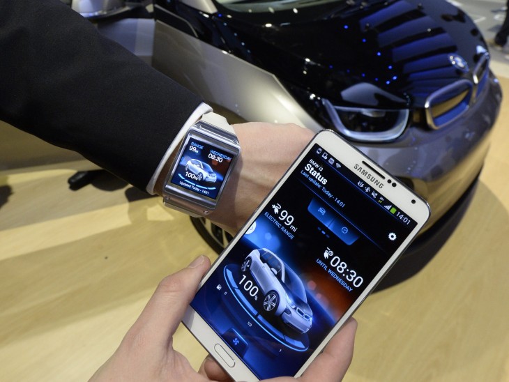 epa04011676 An exhibitor shows the Samsung smart watch and smart phone that interact with the BMW 3i electric car at the Las Vegas Convention Center a...