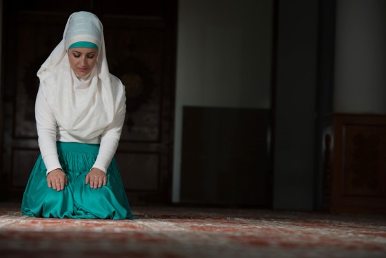 Young Muslim Woman Praying In Mosque; allah; arabic; belief; clothing; east; eid; faith; female; girl; god; hands; hijab; holy; iftar; interior; islam...