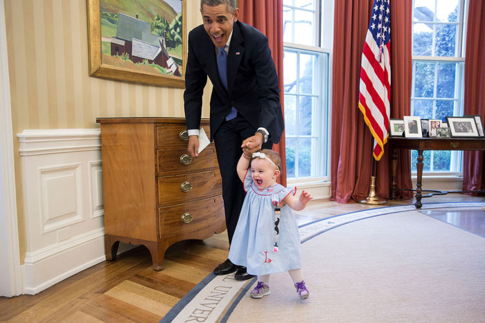 Obama plays with baby in Oval Office.