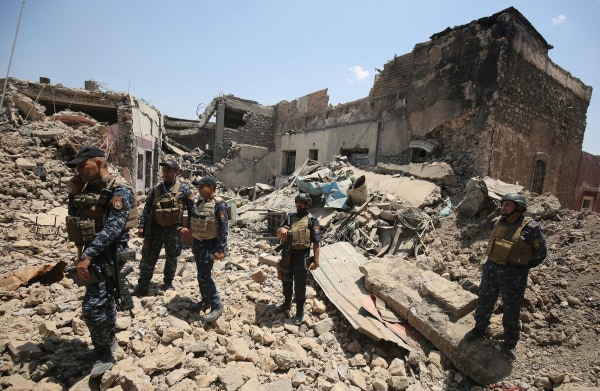 Image: Iraqi forces stand in the rubble of a building as they advance towards Mosul's Old City