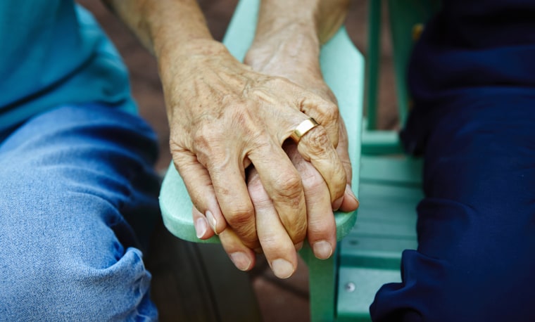 Image: iäkäs pariskunta pitää kättä puistonpenkillä