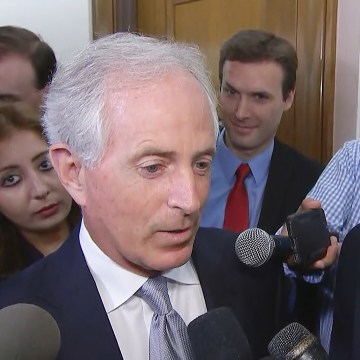 Image: Ryan Clayton of Americans Take Action stands behind Senator Bob Corker during his stakeout on Capitol Hill on Oct. 24, 2017.