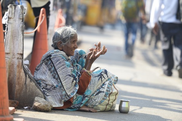   Image: A woman prays at the edge of a road in Hyderabad, India 