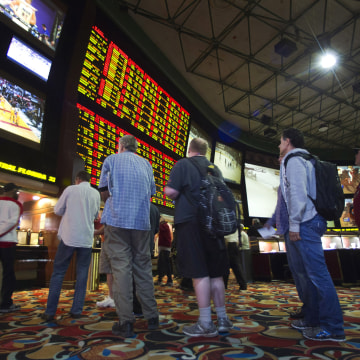 Image: People wait in line to place bets after Super Bowl XLVIII in Las Vegas
