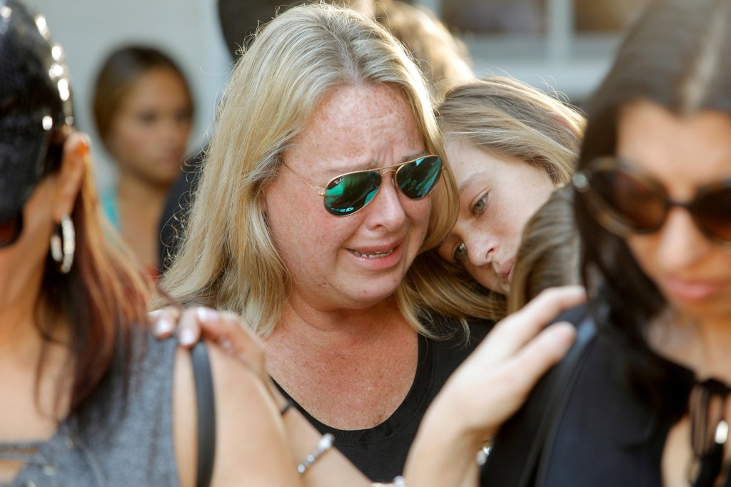 Image: Mourners react during a community prayer vigil at Parkridge Church in Pompano Beach