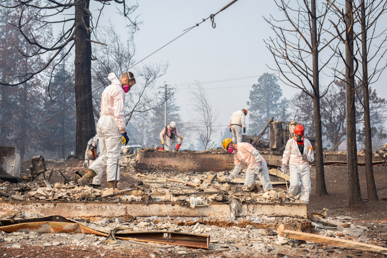 Search and rescue teams work amid a bleak landscape of charred home remains in Paradise, California on Friday. 