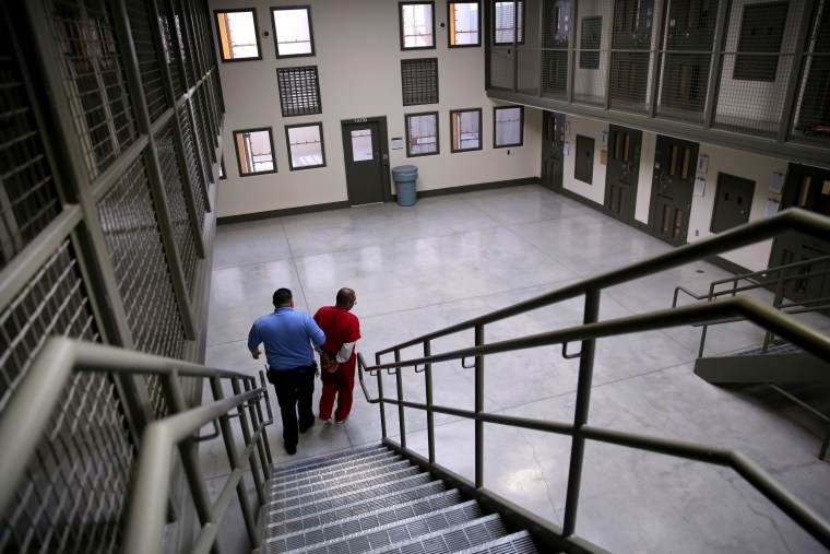 Image: A guard escorts an immigrant detainee from his segregation cell back to general population at the Adelanto Detention Facility in California on Nov. 15, 2013.