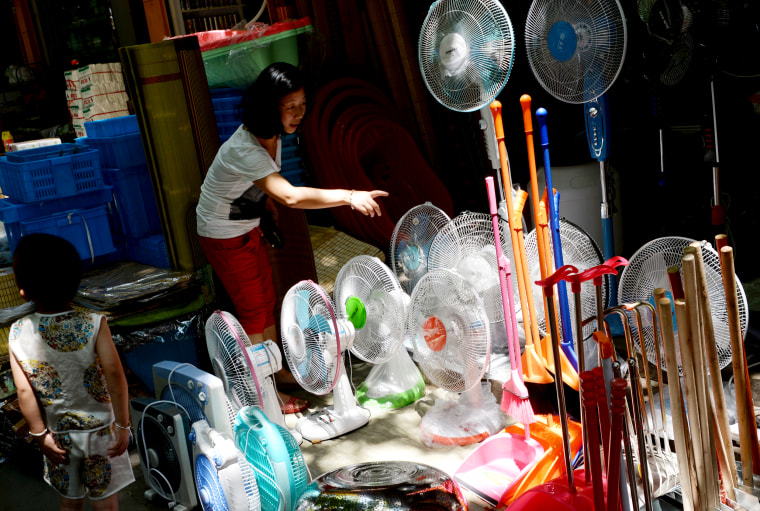 Image: A woman shops for a fan in Jiangshan, China, on July 9, 2013.