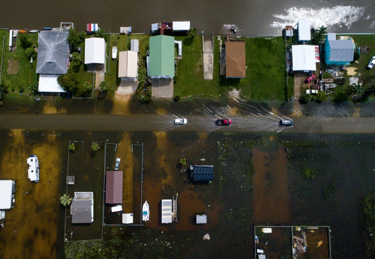 Image: Cars drive through a flooded street in Sargent, Texas, on Sept. 18, 2019.