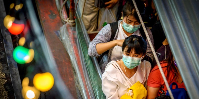 Image: Commuters wear masks to protect against the coronavirus at Pratunam Pier in Bangkok on Jan. 30, 2020.