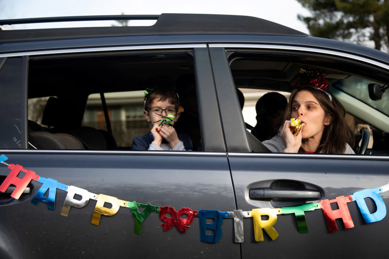 Image: Family and friends line up down the street to wish for a birthday celebration drive-by