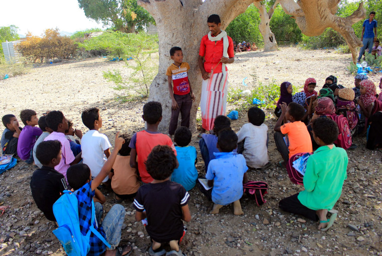 Image: Displaced Yemeni children attend an open air class in the shade of a tree in the district of Abs in the northern Hajjah province