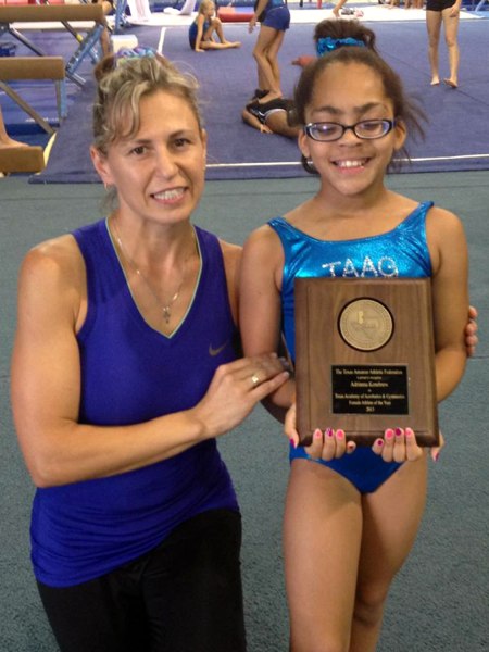 Photo Adrianna and her coach holding the award